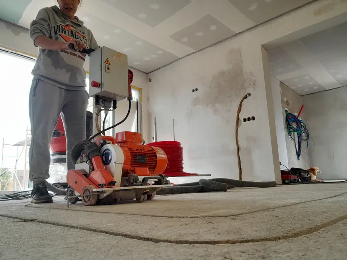 A team member operating a floor preparation machine on site